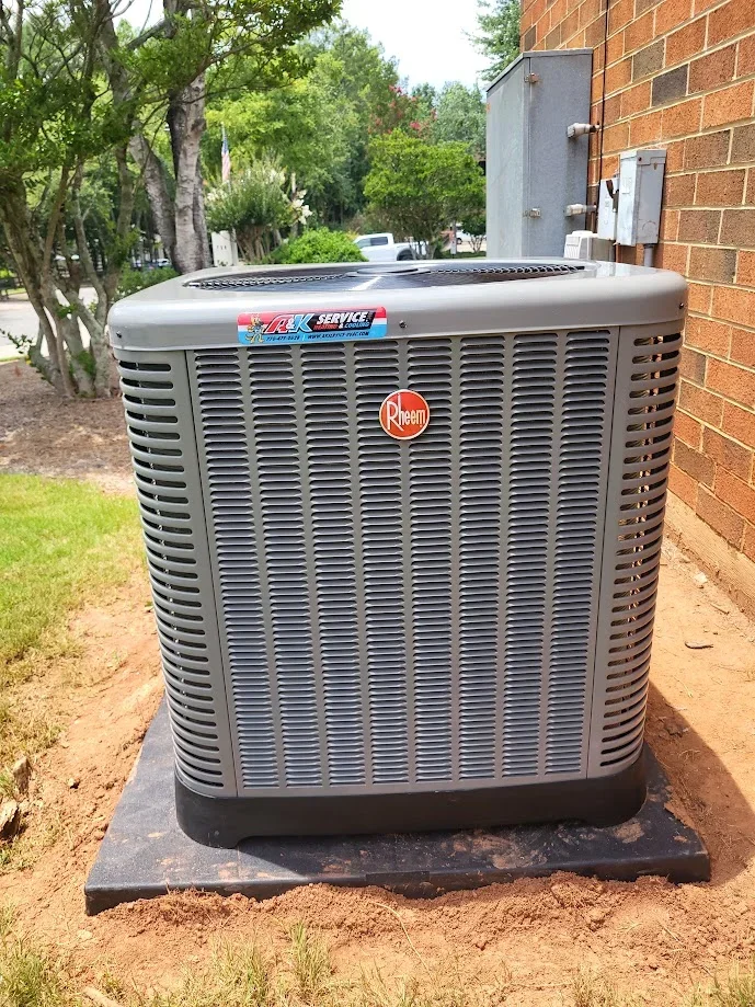 Bryant air conditioning condenser unit installed on concrete pad next to brick home